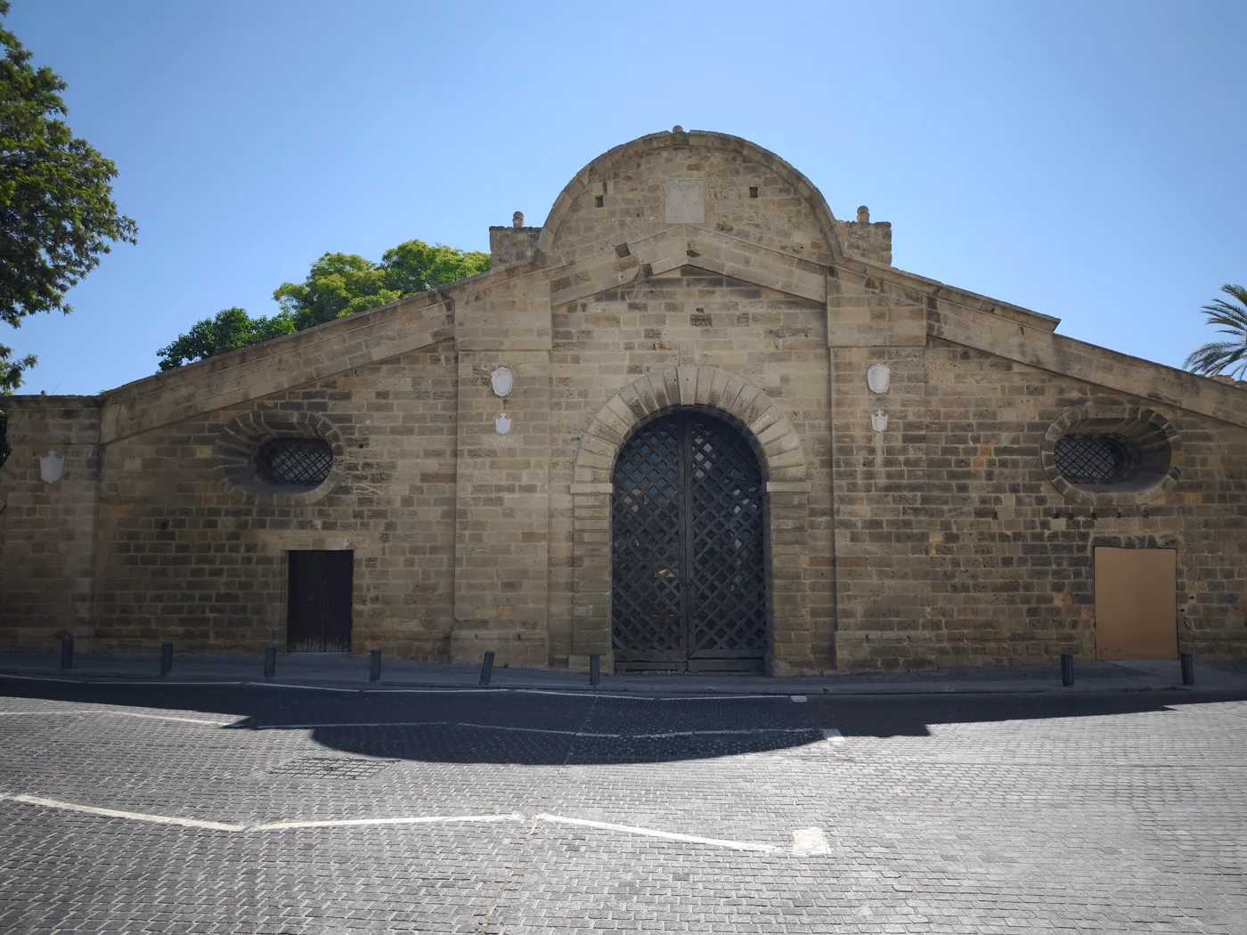 The stone façade of Famagusta Gate in Nicosia’s Venetian walls, a single arched doorway under a low dome, with a paved square in front.